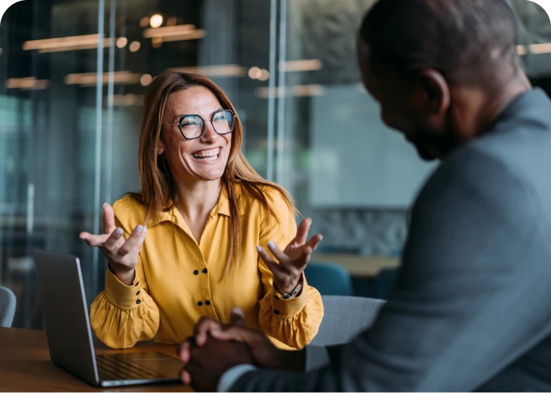 Professional conversation at a desk with laptop