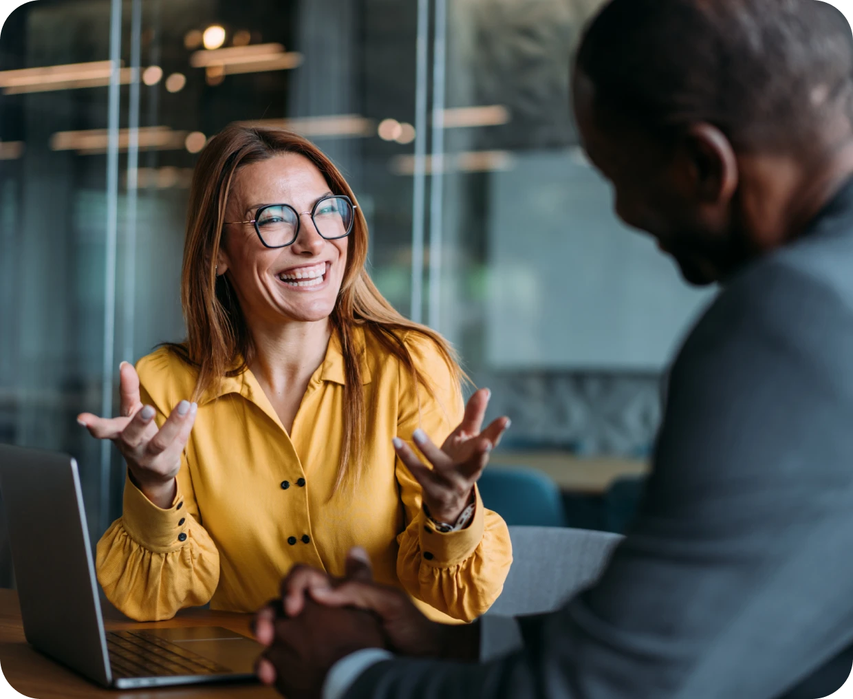 Woman in yellow shirt discussing at work